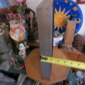 May include: A wooden framed picture with a blue and yellow sun and stars design. The frame is 8 inches tall and is sitting on a wooden surface.