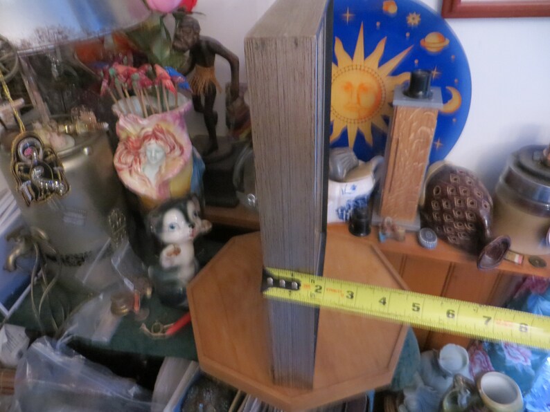 May include: A wooden framed picture with a blue and yellow sun and stars design. The frame is 8 inches tall and is sitting on a wooden surface.