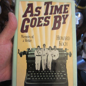 May include: A book titled "As Time Goes By: Memoirs of a Writer" by Howard Koch. The cover features a vintage typewriter and four people in formal attire.