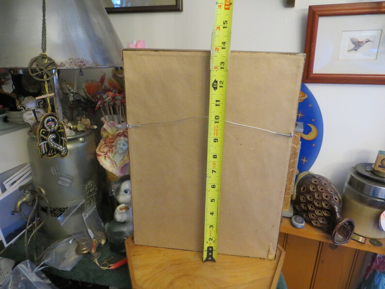 May include: The back of a framed picture with a brown mat and a wood frame. The frame is 15 inches tall.