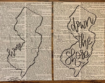 May include: A black and white illustration of the state of New Jersey with the text "Down the Shore" written in a stylised font. The illustration is superimposed on a page of a dictionary.