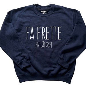 May include: Navy blue sweatshirt with the text "FA FRETTE EN CALISSE!" in white. The crew neck sweatshirt is a solid color and has long sleeves. The brand name is visible on the collar.
