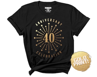 May include: A black short-sleeved t-shirt featuring a gold-colored graphic of a firework burst surrounding the number 40, with the text ANNIVERSARY CELEBRATION arched above and below. A circular gold-textured badge displays the text GOLD PRINT!