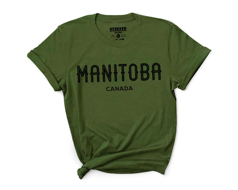 May include: An olive green t-shirt with the word "MANITOBA" in black, arched text, and "CANADA" below it. The shirt has rolled-up sleeves and a crew neck. The brand name "KEBEKER DESIGN" is printed on the upper left.