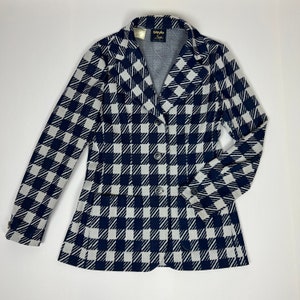 May include: A black and white checkered blazer with a button closure and a pocket on the left side. The blazer has a label that reads "Bladylo New York".