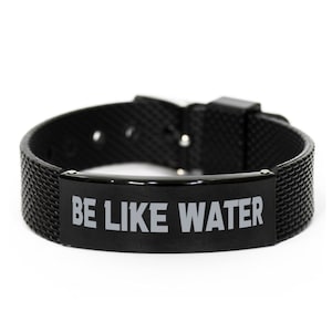 May include: Black silicone bracelet with a black metal plate that says "BE LIKE WATER" in gray lettering.