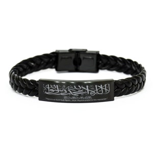 Puede incluir: Pulsera de cuero trenzado negro con una placa metálica rectangular. La placa presenta caligrafía árabe y el texto en inglés "There is no God but Allah, and Muhammad is his messenger."