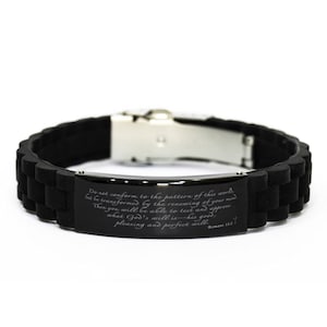 May include: Black silicone bracelet with a silver clasp and a black metal plate engraved with the Bible verse "Do not conform to the pattern of this world, but be transformed by the renewing of your mind. Then you will be able to test and approve what God's will is—his good, pleasing and perfect will." Romans 12:2