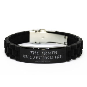 Puede incluir: Pulsera de silicona negra con cierre plateado y una placa de metal negro grabada con las palabras "THE TRUTH WILL SET YOU FREE JOHN 8:32".