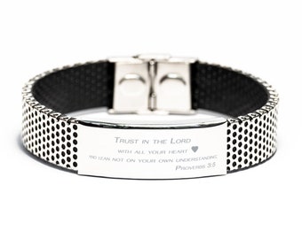 Puede incluir: Una pulsera de plata con una banda negra y una placa de plata grabada con la cita "Trust in the Lord with all your heart and lean not on your own understanding. Proverbs 3:5".