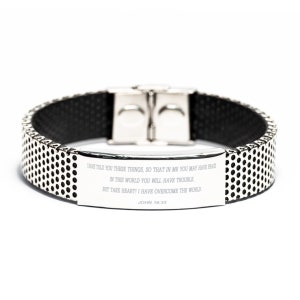 May include: A silver bracelet with a black inner band and a perforated outer band. The bracelet has a rectangular plate with engraved text from John 16:33. The clasp is silver.