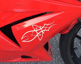 May include: A red Kawasaki motorcycle with a white tribal design on the side. The motorcycle has a black seat and a black front fender.