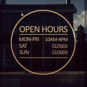 May include: A gold circle sign with the text "Open Hours" and the following hours of operation: Mon-Fri 10AM-4PM, Sat Closed, Sun Closed.