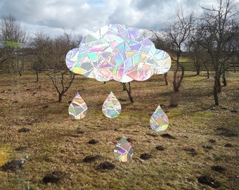 May include: A colorful, iridescent cloud with raindrops falling over a field of brown grass and bare trees. The cloud and raindrops are made of mosaic tiles.