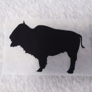 May include: Black silhouette of a bison on a white background.