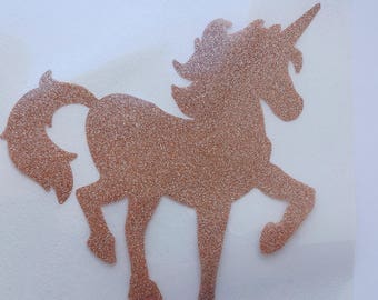 May include: A gold glitter unicorn silhouette on a white background.