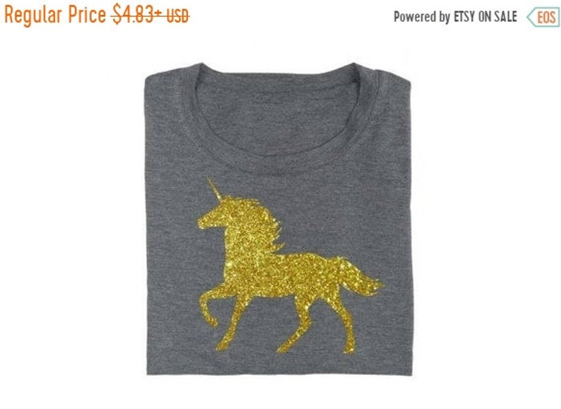 May include: A gray t-shirt with a gold glitter unicorn design.