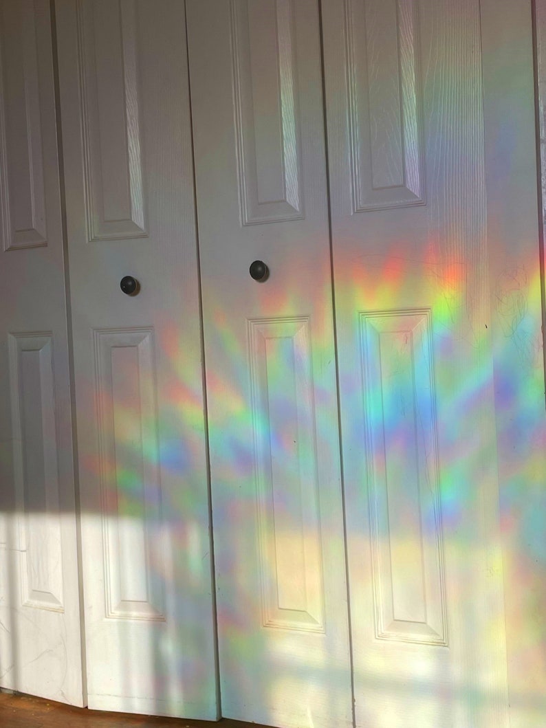 May include: White closet doors with a rainbow prism light reflection on the surface.
