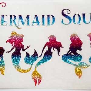 May include: Five iridescent mermaid silhouettes with rainbow glitter, arranged in a row. The text "Mermaid Squad" is above the mermaids.