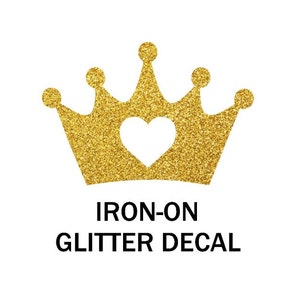 Może przedstawiać: Złota naklejka z brokatem do prasowania w kształcie korony z sercem w środku.  "IRON-ON GLITTER DECAL" jest napisane pod koroną.