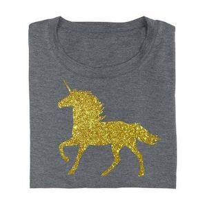 May include: A gray t-shirt with a gold glitter unicorn silhouette.