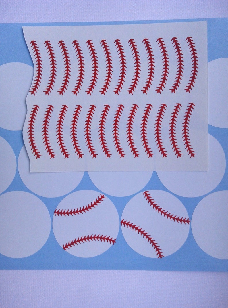 May include: A sheet of white sticker paper with red baseball stitch designs. There are two baseball stickers with red stitches on white circles.
