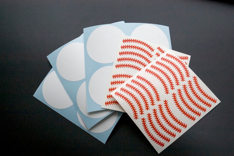 May include: A set of white circle stickers with a sheet of red baseball stitch pattern stickers.