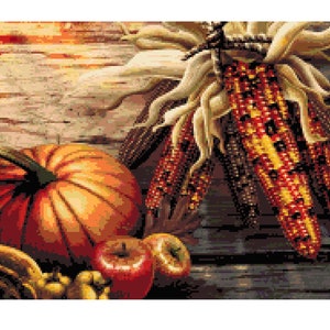 May include: A still life featuring a large orange pumpkin, red apples, and a bundle of colorful corn on the cob with dried husks. The background is a rustic wooden surface with a faded, light brown frame.