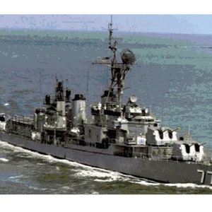 May include: A gray naval destroyer ship with the number 779 on the side, sailing on the ocean.