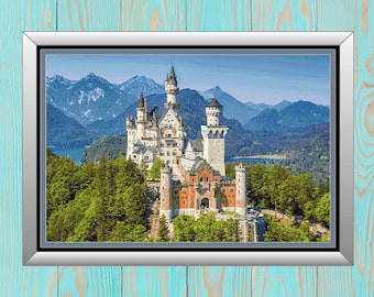 May include: A framed print of a white castle with red accents, surrounded by green trees and mountains in the background. The castle is set against a blue sky with white clouds.
