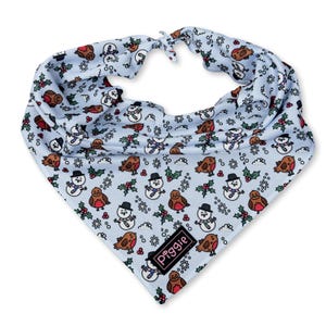 May include: A light blue dog bandana with a repeating pattern of snowmen, robins, and holly. The bandana is tied at the top and features a small black and white label with the word "Piggies".