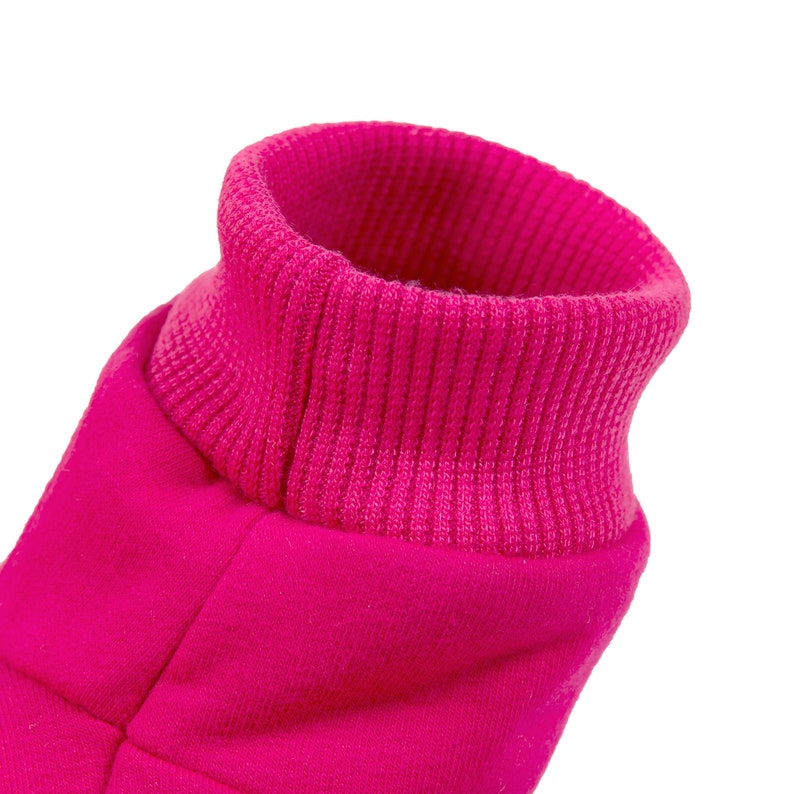 May include: A close-up of a pink fleece jacket with a ribbed collar. The collar is folded down and the fabric is soft and fuzzy.