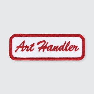 May include: White rectangular patch with a red border and the text "Art Handler" embroidered in red.