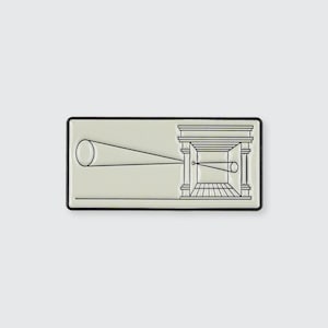 Könnte beinhalten: Eine weiße Emaille-Anstecknadel mit schwarzem Umriss, die eine geometrische Form mit einem Kreis im Inneren darstellt. Die Form ähnelt einem Gebäude mit einer Tür und einem Fenster.