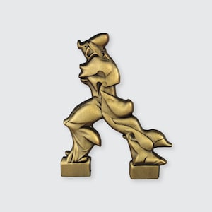 Può includere: Una scultura in metallo dorato che rappresenta una persona in una posa dinamica, in piedi su due basi rettangolari. La scultura è astratta e stilizzata, con gli arti e il torso della figura contorti in una forma interessante.