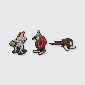 May include: Set of three enamel pins featuring cartoon characters. The first pin features a character with a red hat and a gray body. The second pin features a character with a red hat and a red body. The third pin features a character with brown hair and a red body.