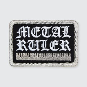 May include: Black embroidered patch with white lettering that reads "METAL RULER" with a silver ruler graphic underneath.