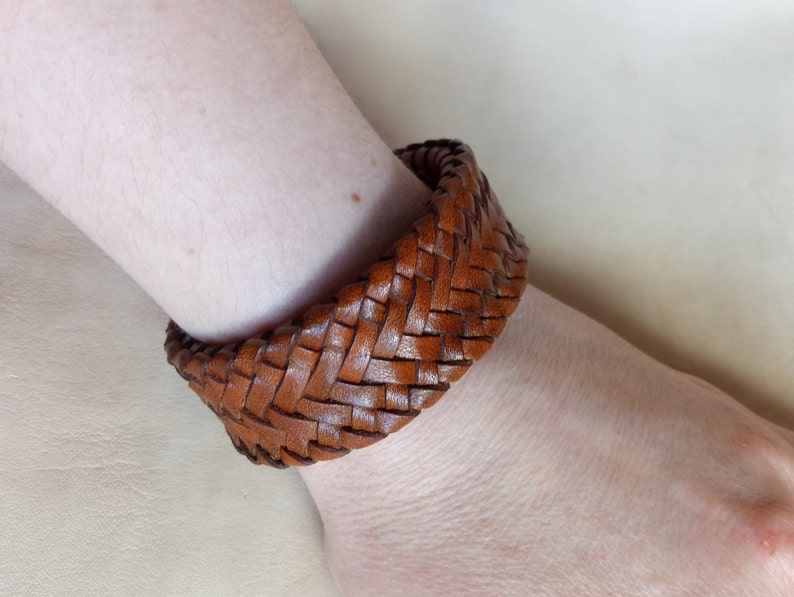 K&ouml;nnte beinhalten: Ein braunes Lederarmband mit geflochtenem Muster.