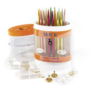 May include: A set of colourful interchangeable circular knitting needles in a clear plastic container with a bright orange lid. The container has the text "SLICK" and "PONY" on it. The needles are in a variety of colours, including pink, green, gold, and silver. The container also includes a set of clear plastic cords and two gold metal connectors.