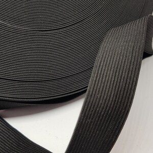 May include: A roll of black elastic band, coiled and folded, showing the texture of the fabric.