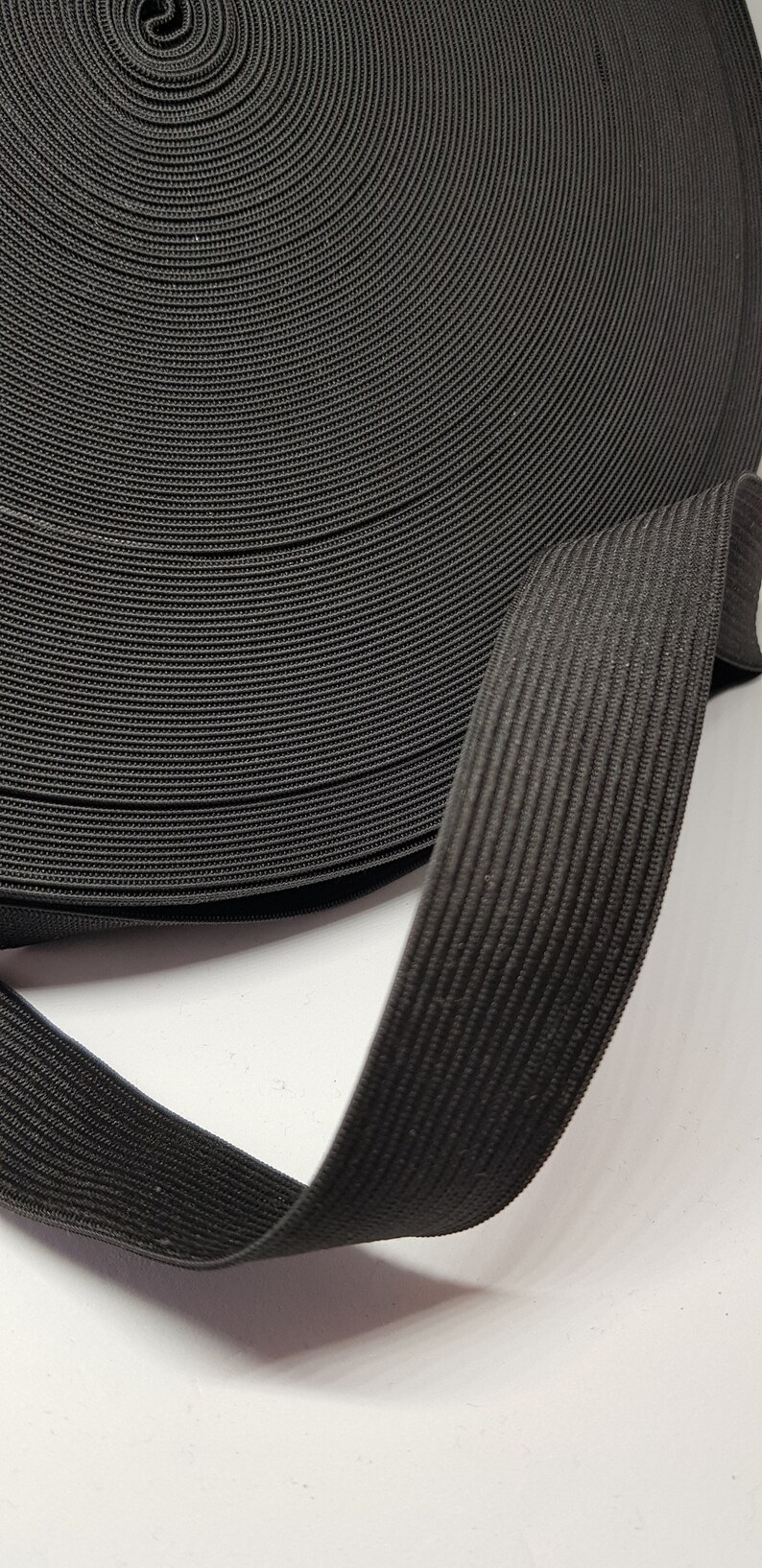 May include: A roll of black elastic band, coiled and folded, showing the texture of the fabric.