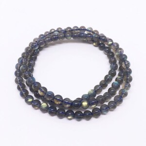 May include: A multi-strand bracelet made of dark blue labradorite beads. The beads have a subtle iridescent sheen.