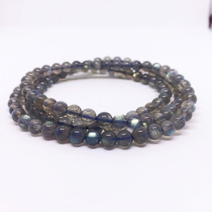 May include: A multi-strand bracelet made of dark gray labradorite beads. The beads have a subtle iridescent sheen.