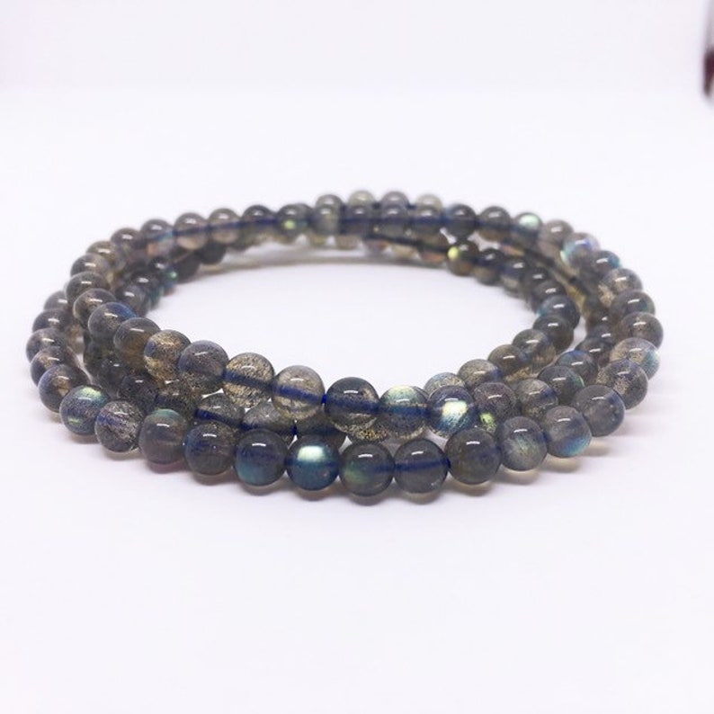 May include: A multi-strand bracelet made of dark gray labradorite beads. The beads have a subtle iridescent sheen.