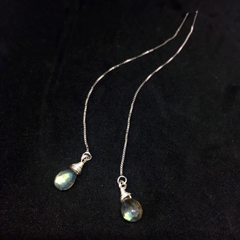 May include: A pair of silver chain earrings with teardrop-shaped iridescent green labradorite stones.