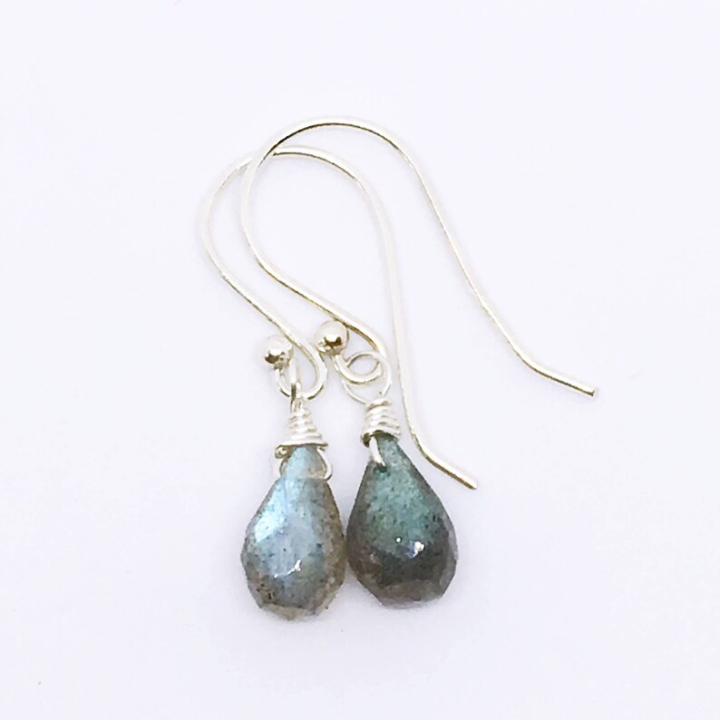 May include: A pair of silver dangle earrings with teardrop-shaped labradorite stones.