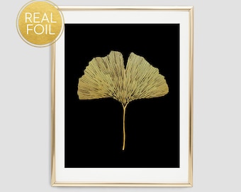 May include: Gold foil ginkgo leaf print on a black background in a gold frame.
