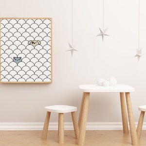Op de afbeelding: Een ingelijst print met een zwart-wit patroon van overlappende halve cirkels. Een katten- en een hondenkop kijken uit achter de halve cirkels. De print hangt aan een witte muur met een witte tafel en twee witte krukken ervoor.