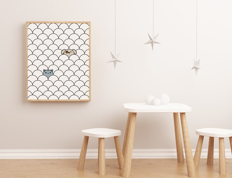 Op de afbeelding: Een ingelijst print met een zwart-wit patroon van overlappende halve cirkels. Een katten- en een hondenkop kijken uit achter de halve cirkels. De print hangt aan een witte muur met een witte tafel en twee witte krukken ervoor.
