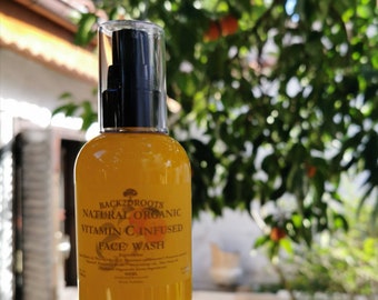 May include: A yellow bottle of Back2Roots Natural Organic Vitamin C Infused Face Wash. The bottle has a black pump top and a white label with the product name and ingredients.